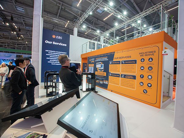 Image of ASC Global's booth featuring a giant print that highlights the company's services, the industries it serves, and its new components marketplace