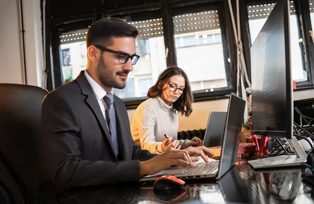 Image of two individuals conducting Market Trend Analysis for ASC Global, reviewing industry data, charts, and reports to identify key trends in the semiconductor and electronics market